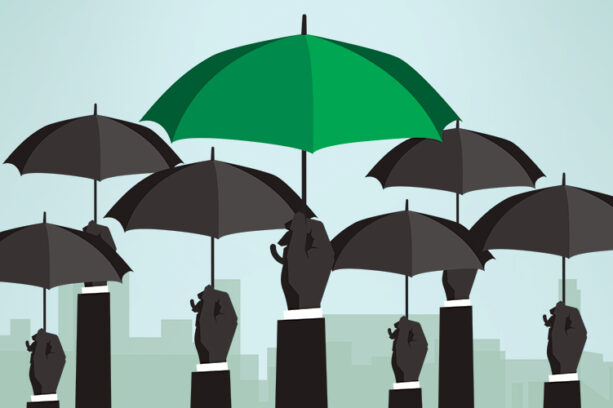 hands holding up black umbrellas with one green umbrealla standing out